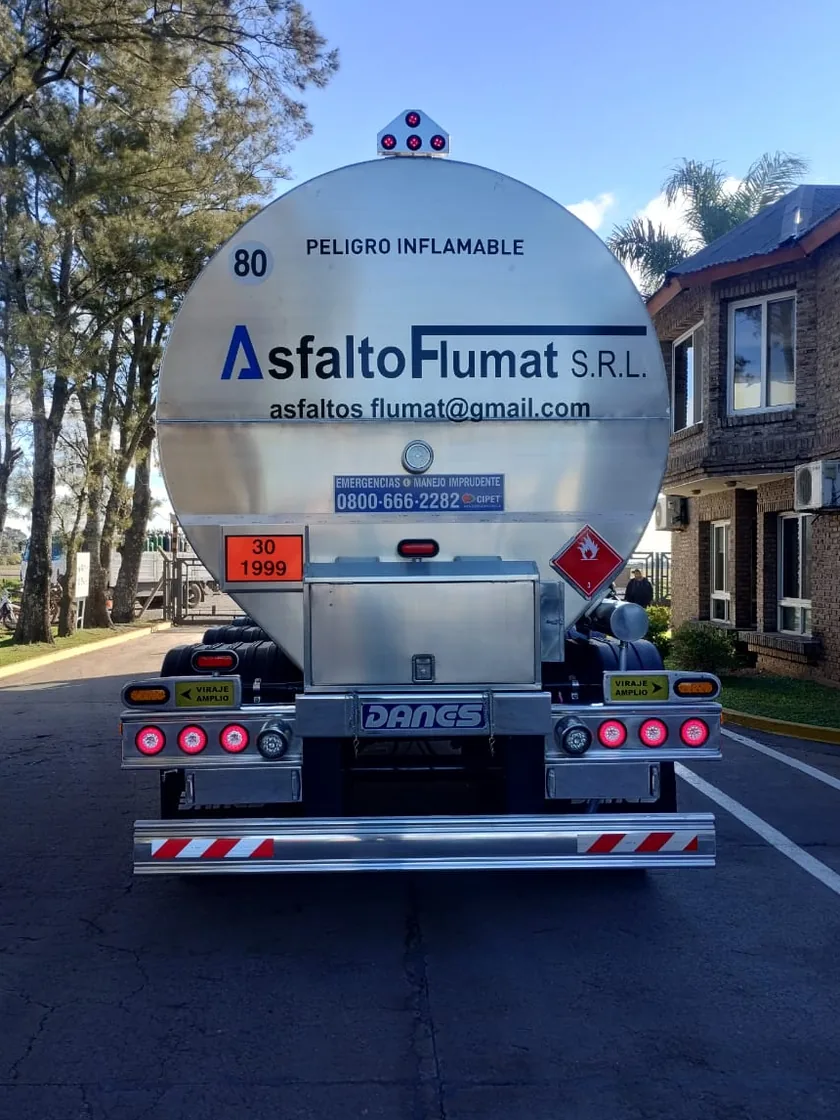 Cisterna asfáltica propia de Flumat vista desde atrás, con el tanque de acero pulido y la rotulación de la empresa.
